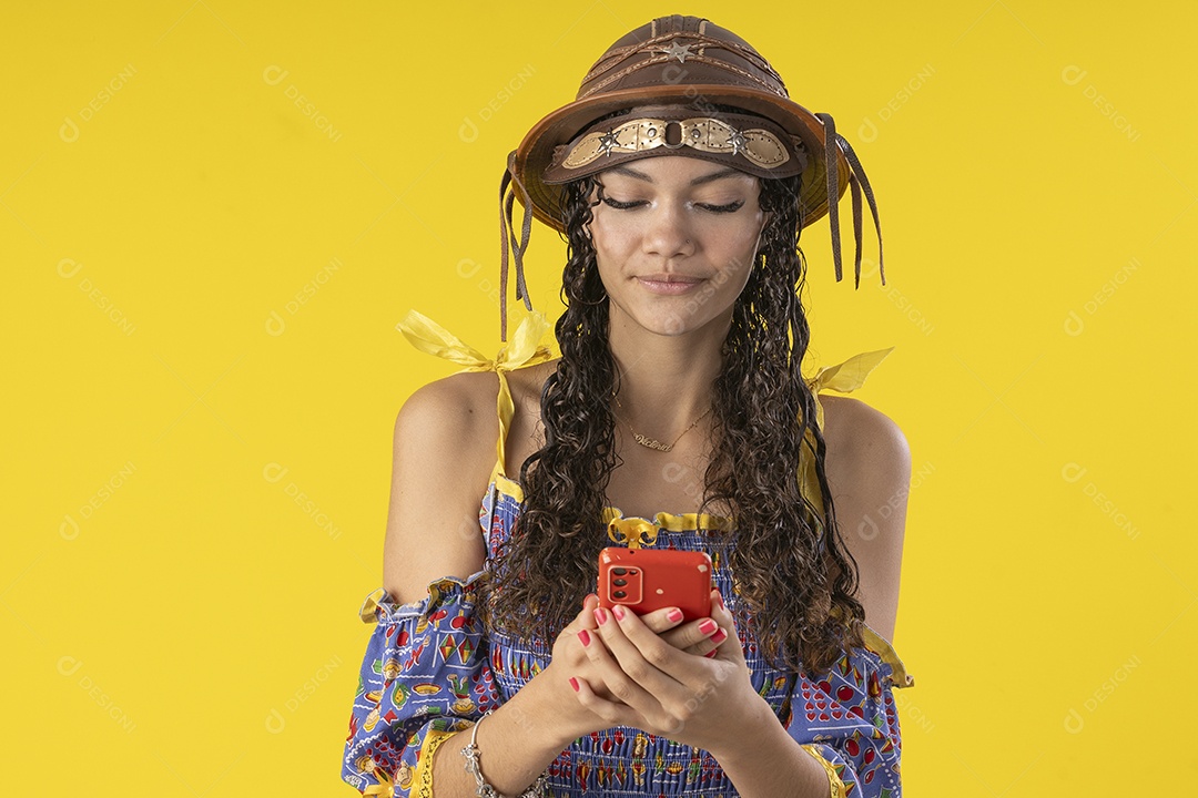 Jovem vestindo fantasia de festa junina com celular nas mãos