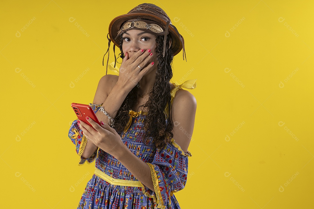 Jovem trajada com roupa junina no celular chamando o pessoal para festa de São João