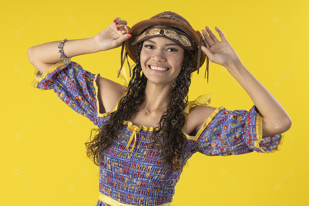 Jovem vestindo fantasia de festa junina com chapéu de couro e sorrindo