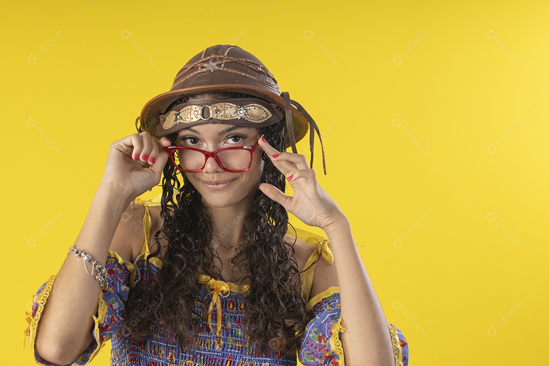 Jovem usando óculos e chapéu de couro típico de festa junina
