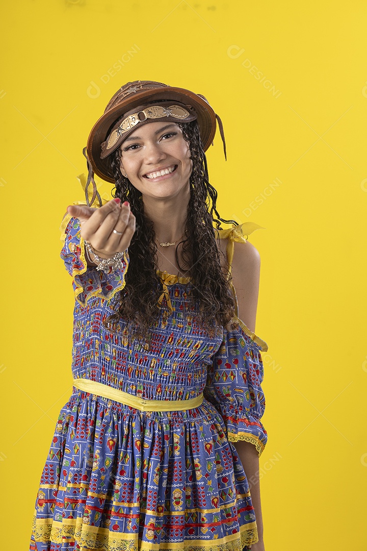 Jovem vestindo fantasia de festa junina com chapéu de couro chamando