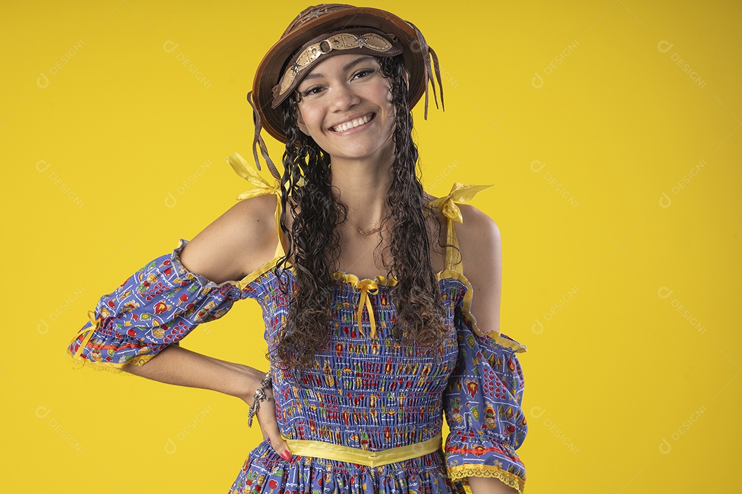 Jovem vestida de trajes juninos segurando no vestido