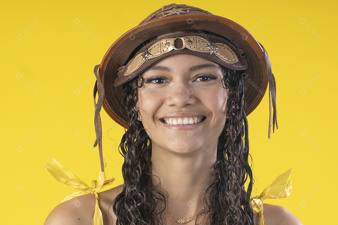 Jovem sorrindo usando chapéu de couro típico de festa junina
