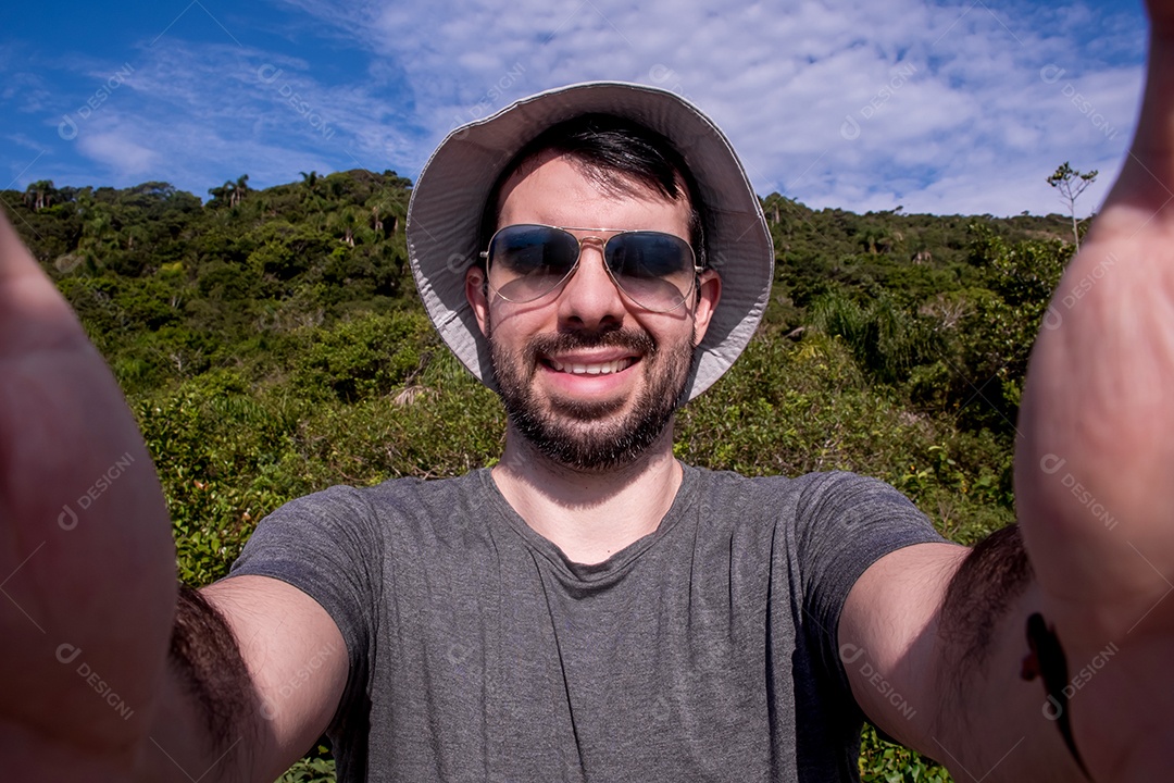 Homem turista de óculos escuros e chapéu tirando uma selfie