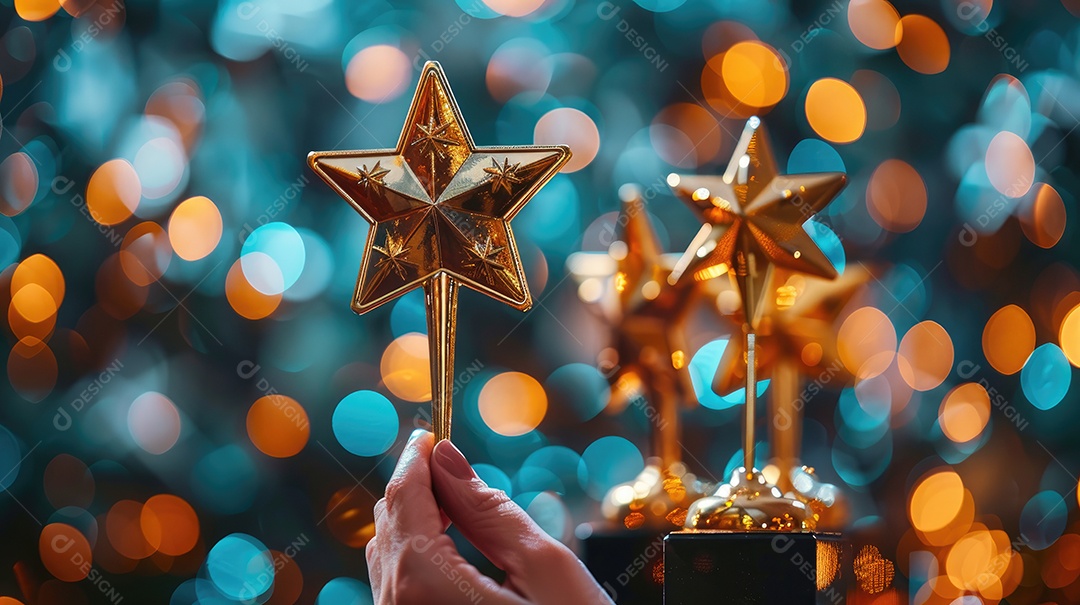 Um close de uma mão segurando cinco prêmios de estrelas douradas cada um brilhando sob uma iluminação suave e focada