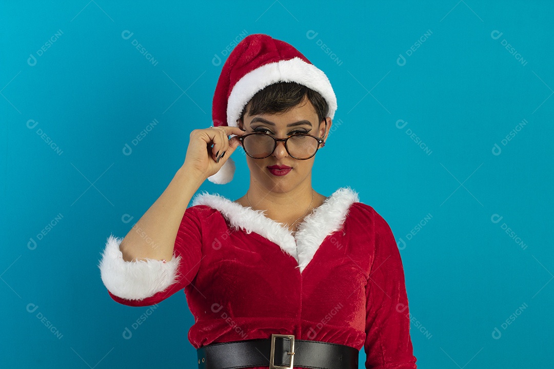 Mulher jovem com roupa de Mamãe Noel e chapéu e usando óculos