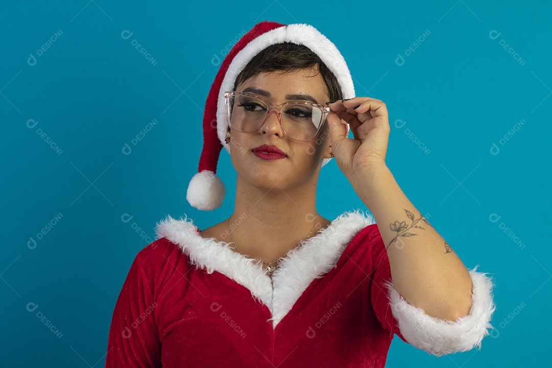 Jovem mulher com roupa de Mamãe Noel e chapéu e usando óculos