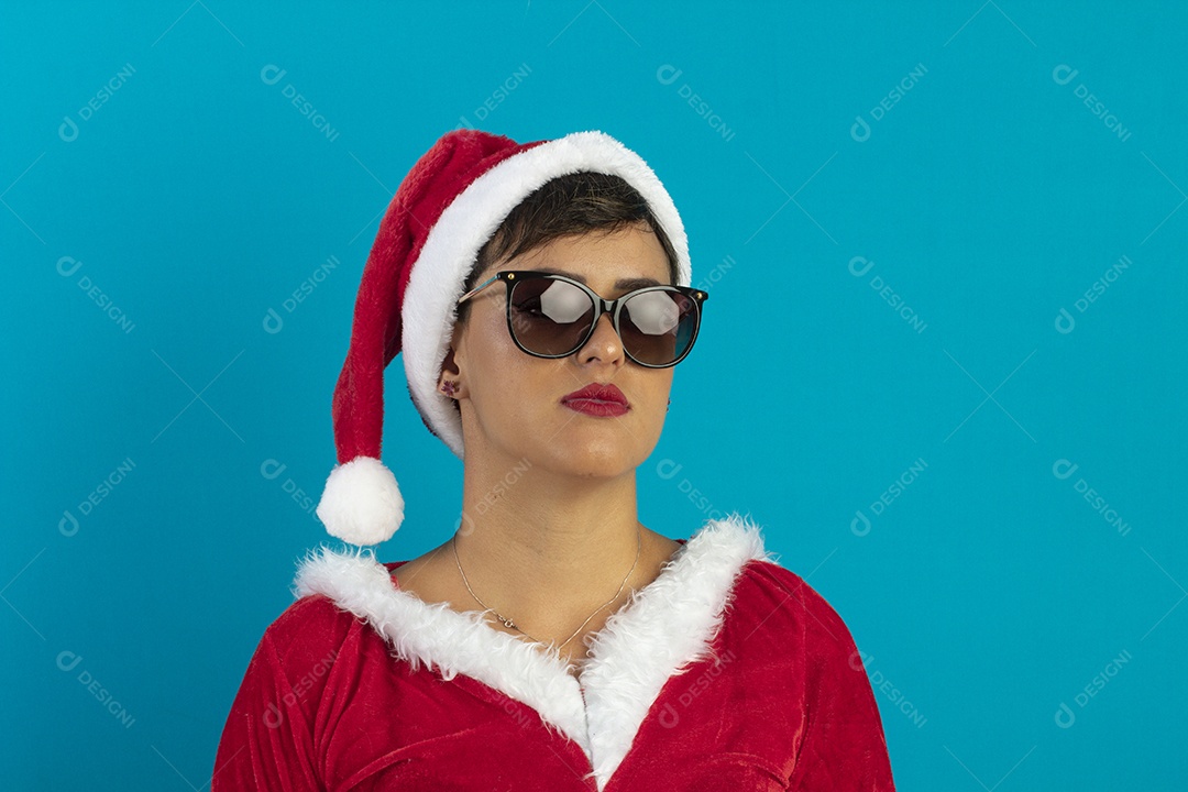 Jovem mulher com roupa de Mamãe Noel e chapéu e usando óculos