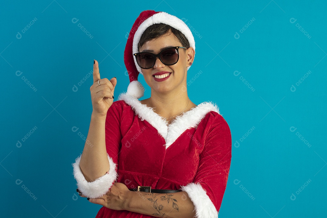 Mulher jovem com roupa de Mamãe Noel e chapéu e usando óculos