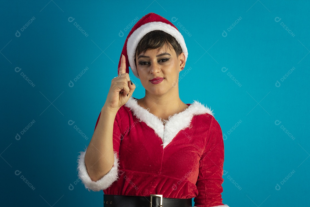 Mulher jovem com roupa de Mamãe Noel e chapéu com gesto de um dedo