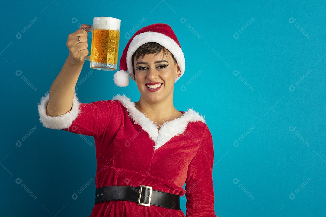 Mulher jovem com roupa de Mamãe Noel e chapéu tomando caneca de chope