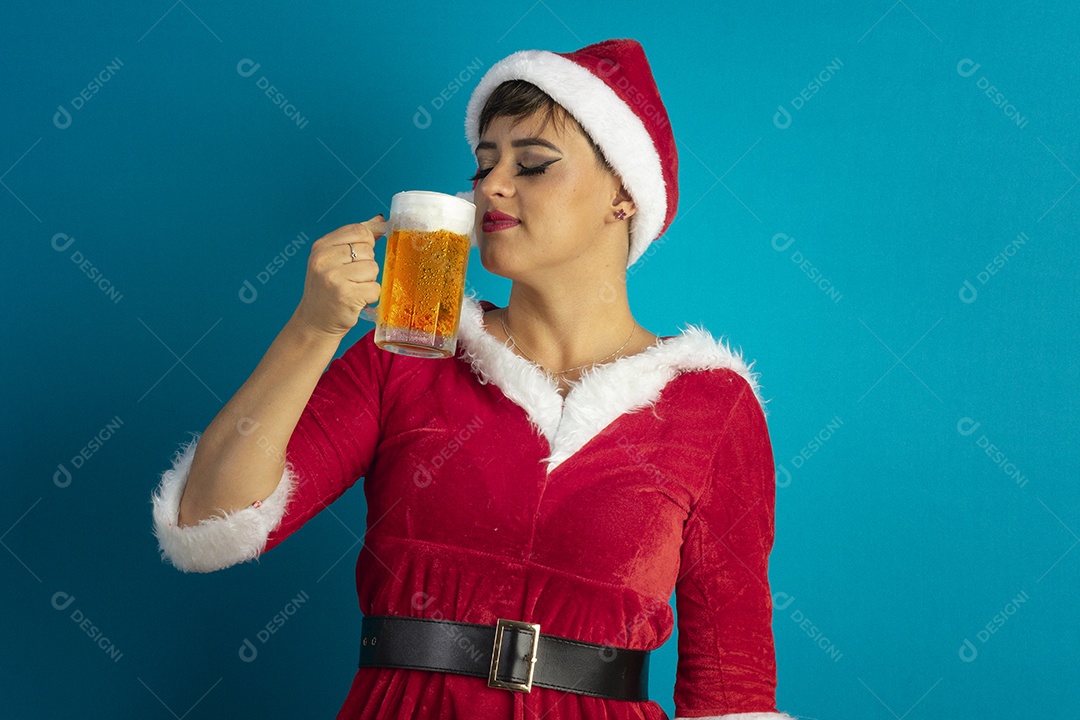 Mulher jovem com roupa de Mamãe Noel e chapéu tomando caneca de chope