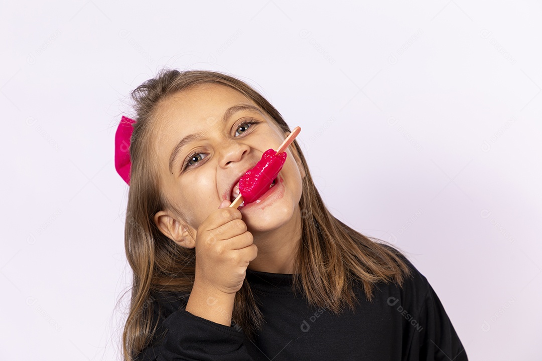 Linda garotinha sobre fundo isolado branco chupando picolé