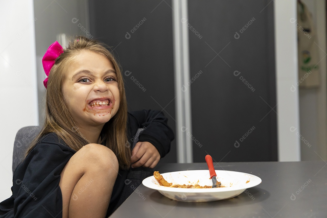Linda garotinha sobre fundo isolado branco se alimentando
