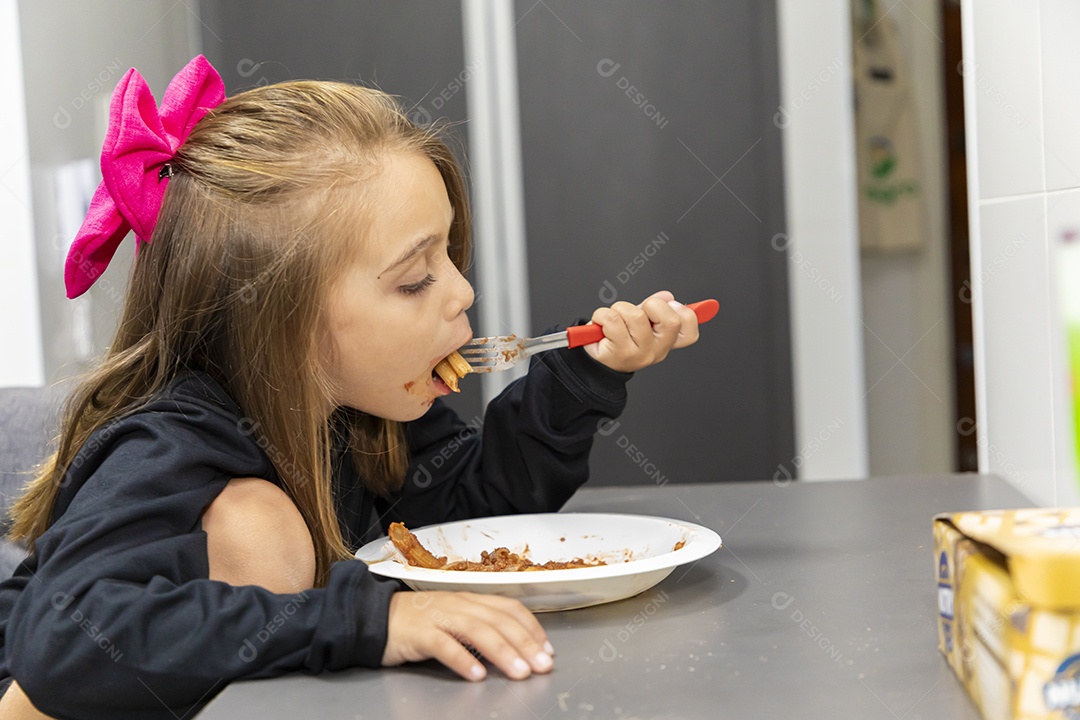 Linda garotinha sobre fundo isolado branco se alimentando