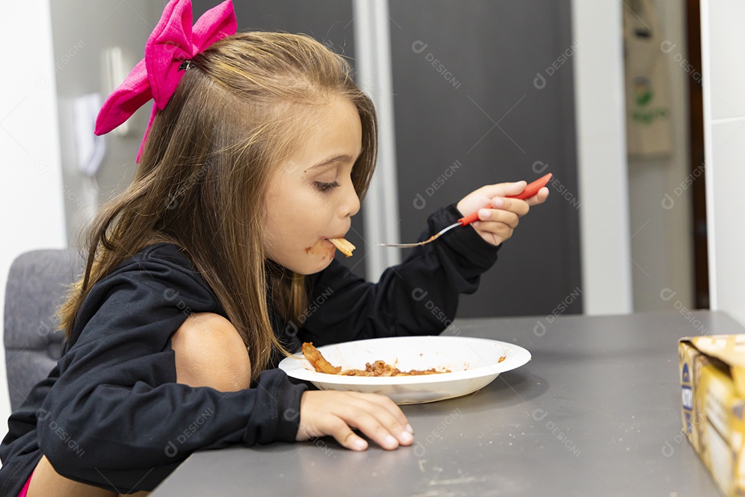 Linda garotinha sobre fundo isolado branco se alimentando