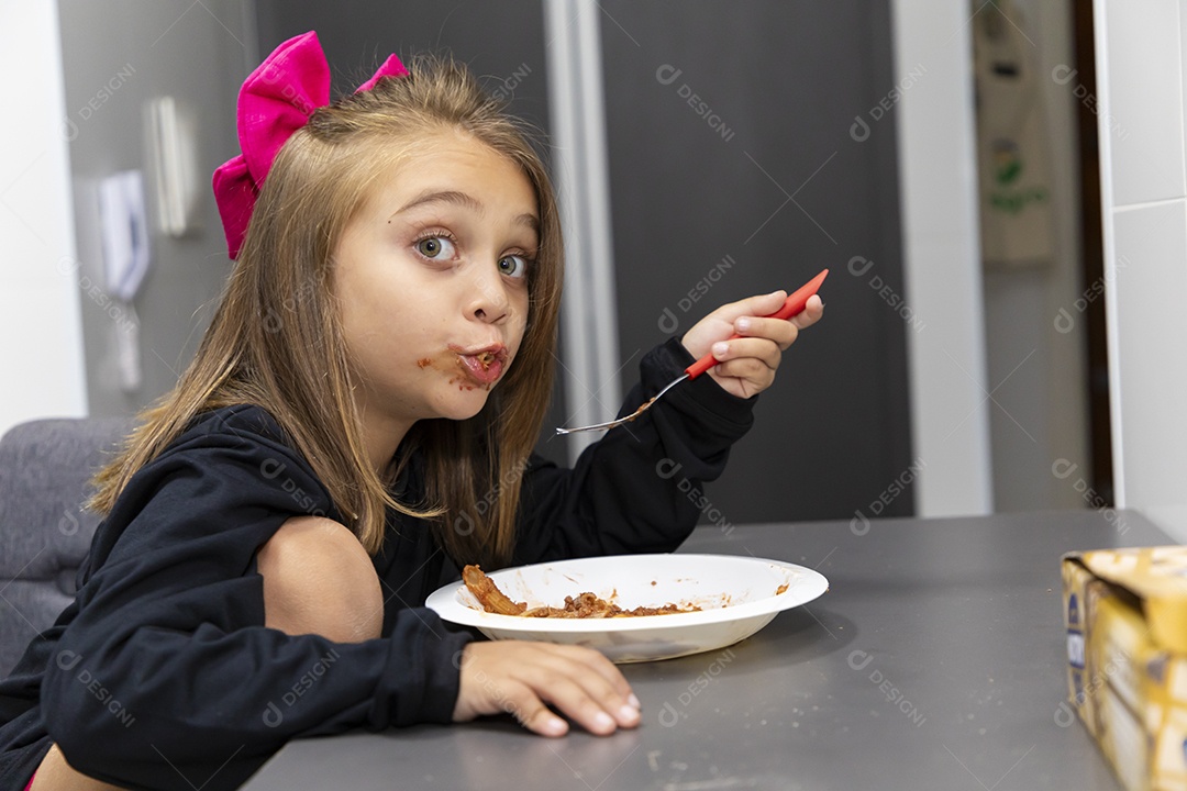 Linda garotinha sobre fundo isolado branco se alimentando