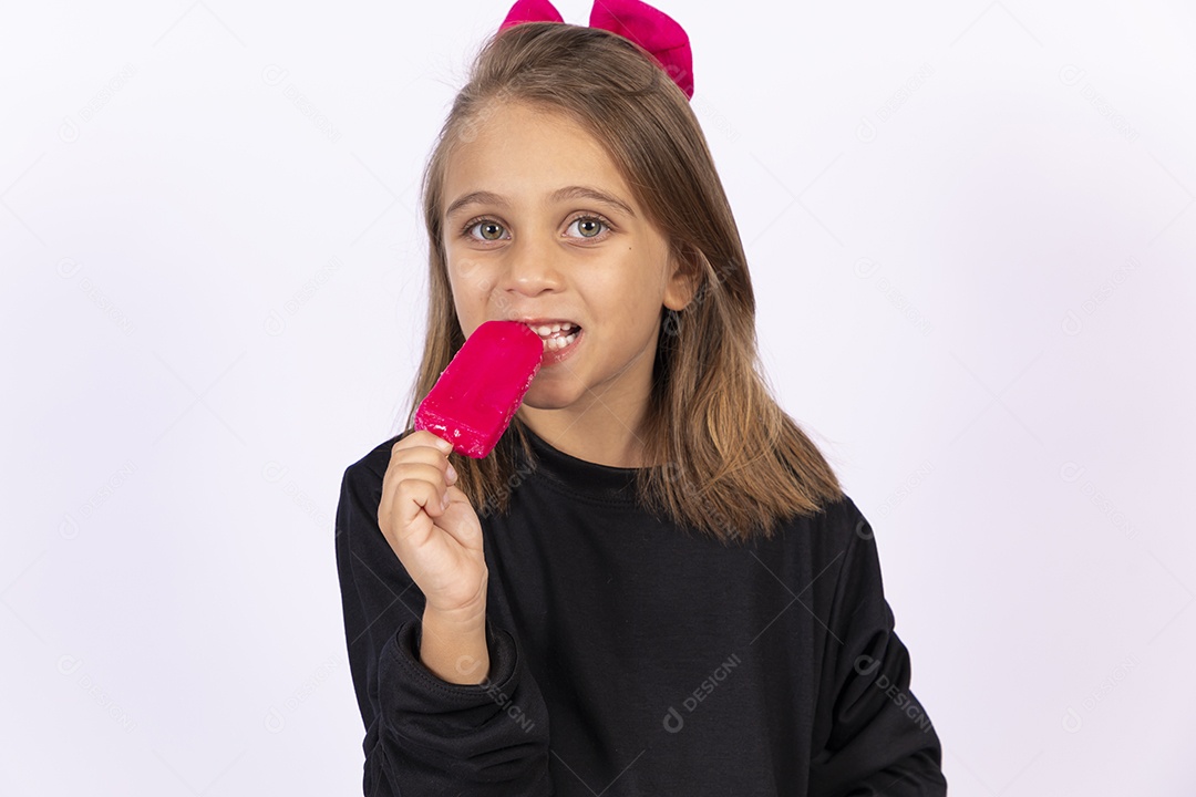 Linda garotinha sobre fundo isolado branco chupando picolé
