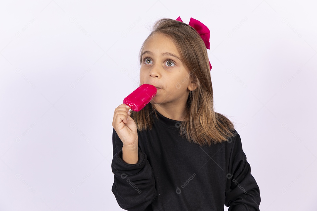 Linda garotinha sobre fundo isolado branco chupando picolé
