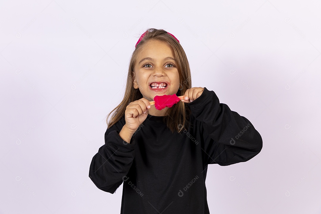 Linda garotinha sobre fundo isolado branco chupando picolé