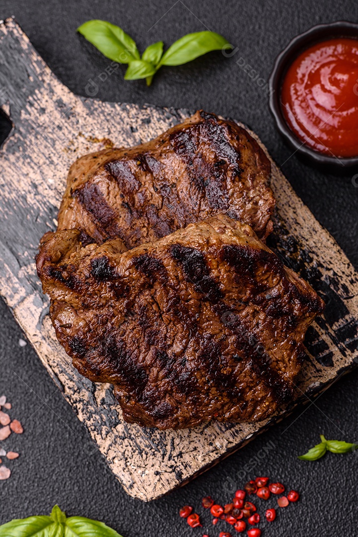 Bife fresco, suculento e delicioso em um fundo escuro. Prato de carne com especiarias e ervas