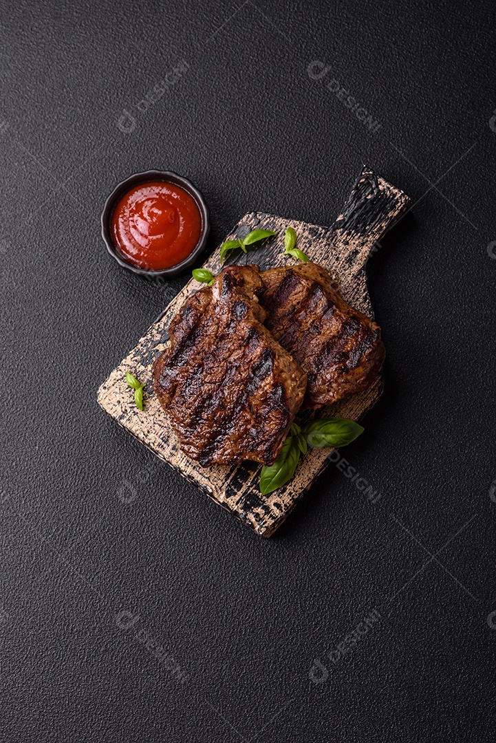 Bife fresco, suculento e delicioso em um fundo escuro. Prato de carne com especiarias e ervas