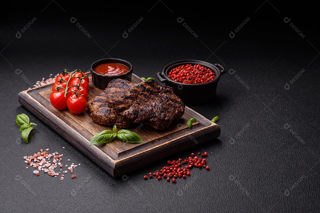 Bife fresco, suculento e delicioso em um fundo escuro. Prato de carne com especiarias e ervas