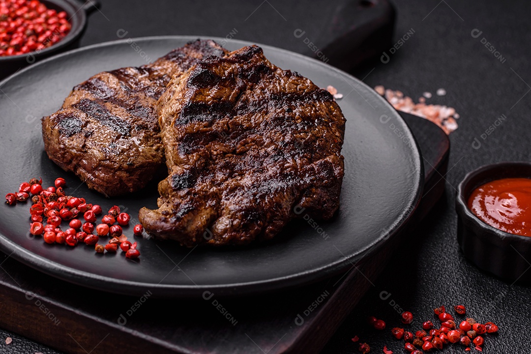 Bife fresco, suculento e delicioso em um fundo escuro. Prato de carne com especiarias e ervas