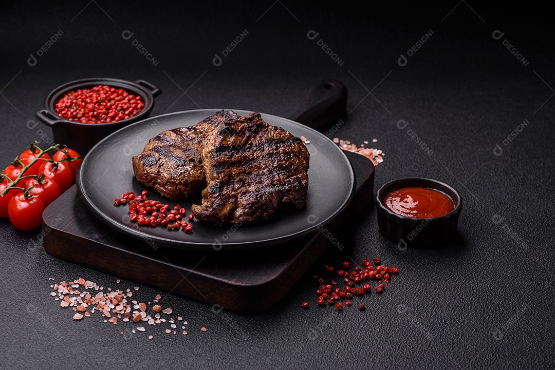 Bife fresco, suculento e delicioso em um fundo escuro. Prato de carne com especiarias e ervas