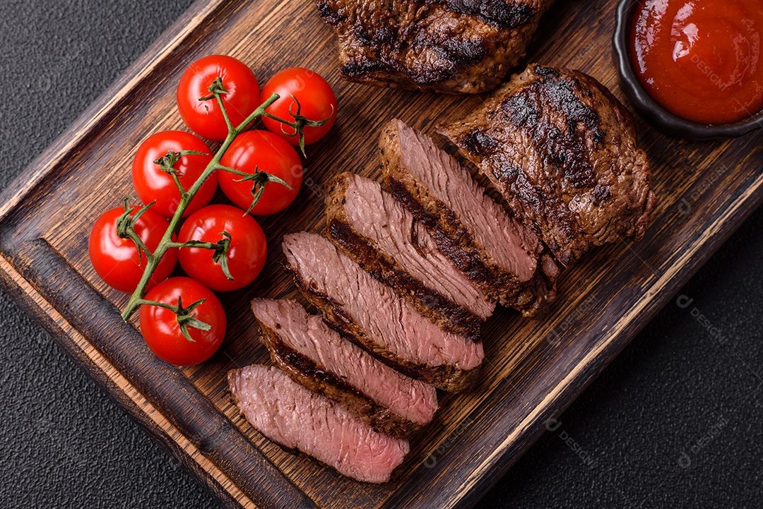 Bife suculento de tomahawk com osso assado na grelha com sal e especiarias em um fundo escuro de concreto