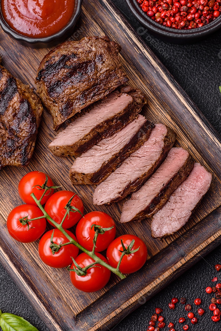 Bife fresco, suculento e delicioso em um fundo escuro. Prato de carne com especiarias e ervas