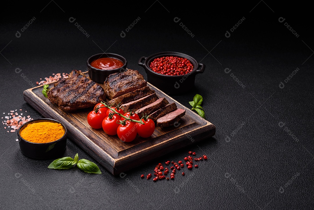 Bife suculento de tomahawk com osso assado na grelha com sal e especiarias em um fundo escuro de concreto