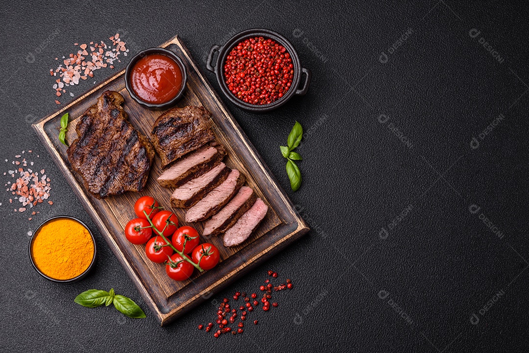 Bife suculento de tomahawk com osso assado na grelha com sal e especiarias em um fundo escuro de concreto