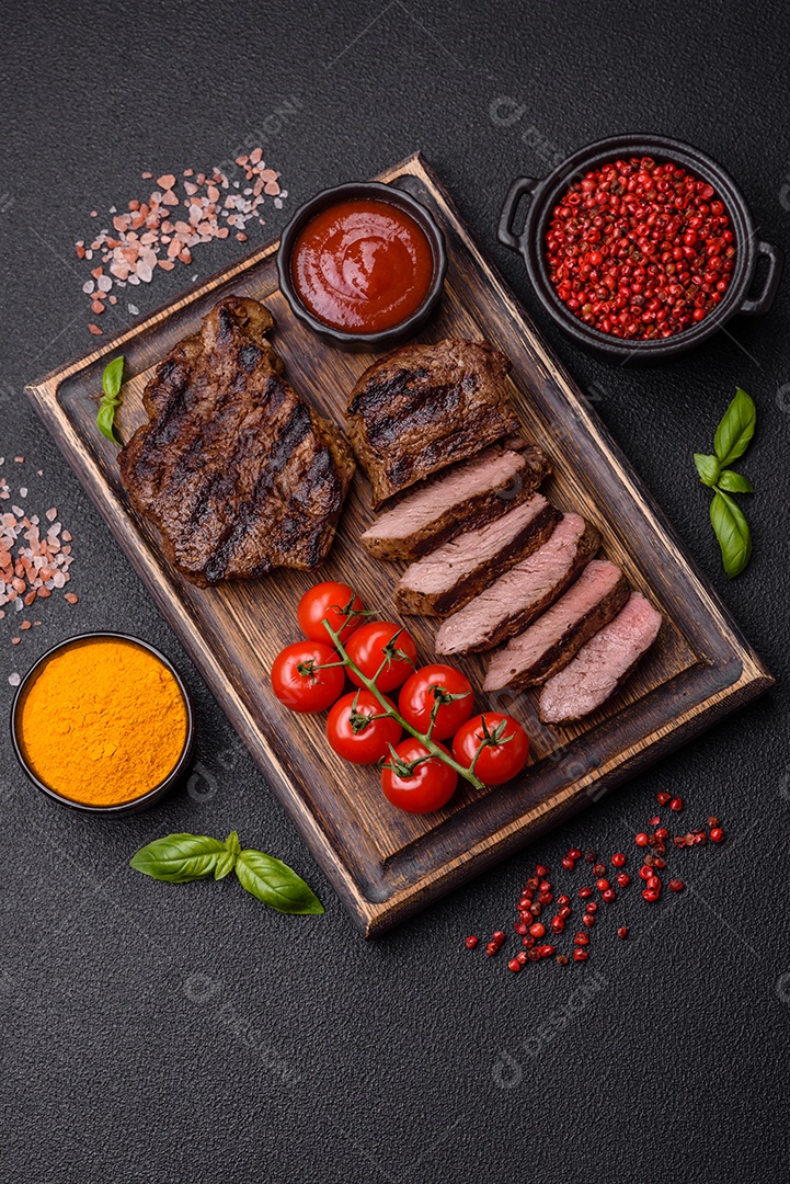 Bife suculento de tomahawk com osso assado na grelha com sal e especiarias em um fundo escuro de concreto