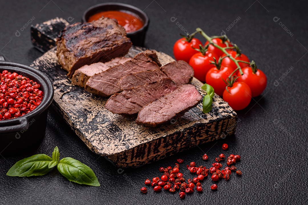 Bife suculento de tomahawk com osso assado na grelha com sal e especiarias em um fundo escuro de concreto