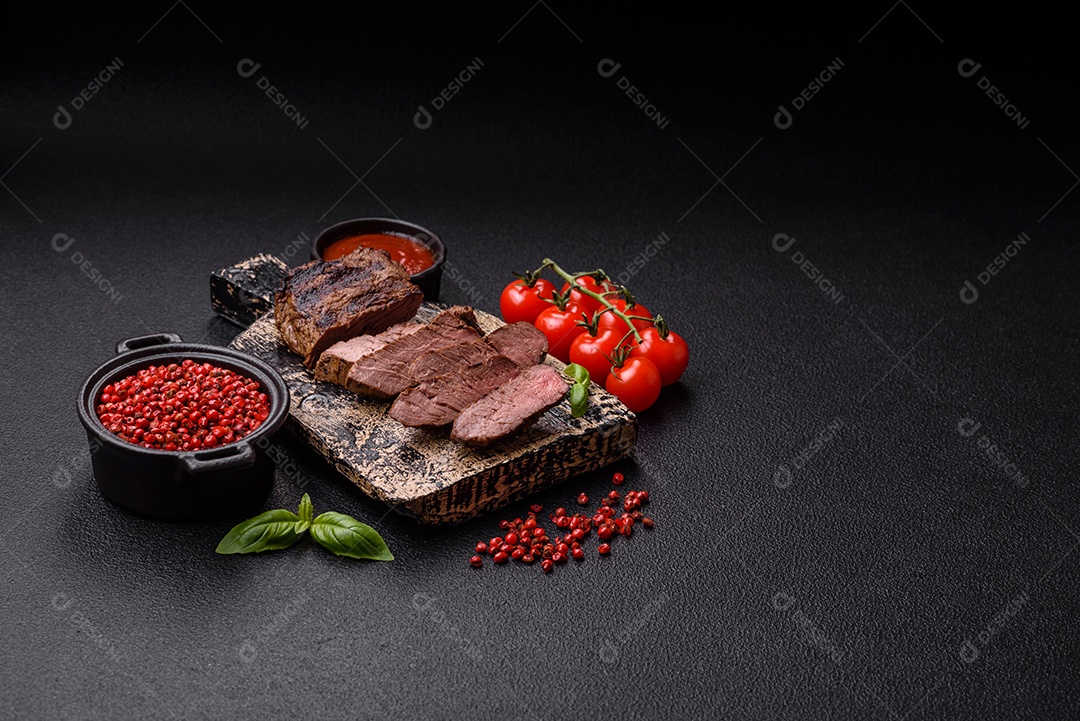 Bife suculento de tomahawk com osso assado na grelha com sal e especiarias em um fundo escuro de concreto