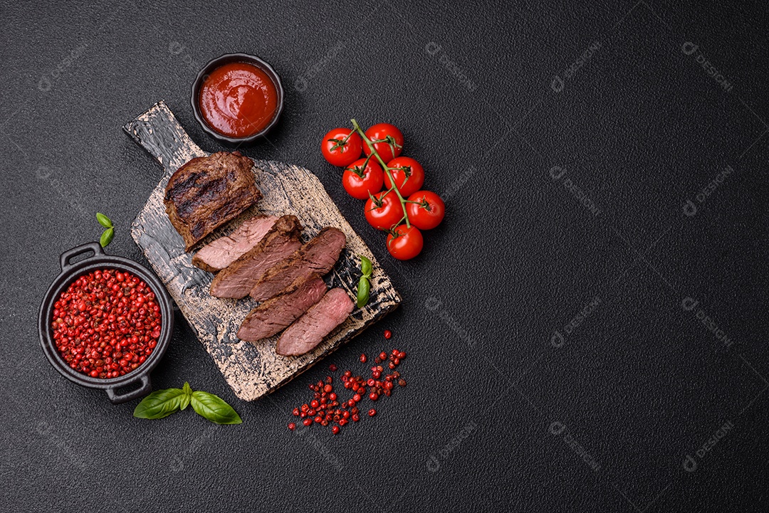 Bife suculento de tomahawk com osso assado na grelha com sal e especiarias em um fundo escuro de concreto