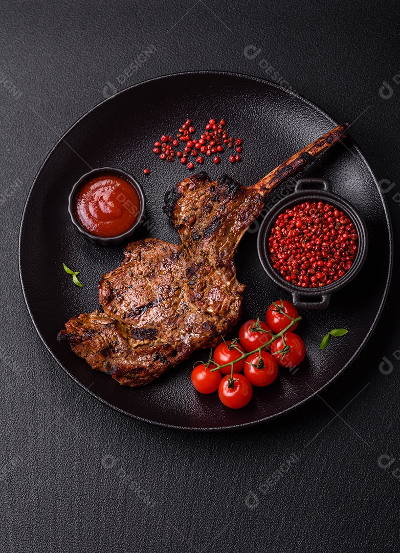 Bife suculento de tomahawk com osso assado na grelha com sal e especiarias em um fundo escuro de concreto
