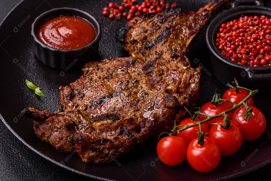 Bife suculento de tomahawk com osso assado na grelha com sal e especiarias em um fundo escuro de concreto