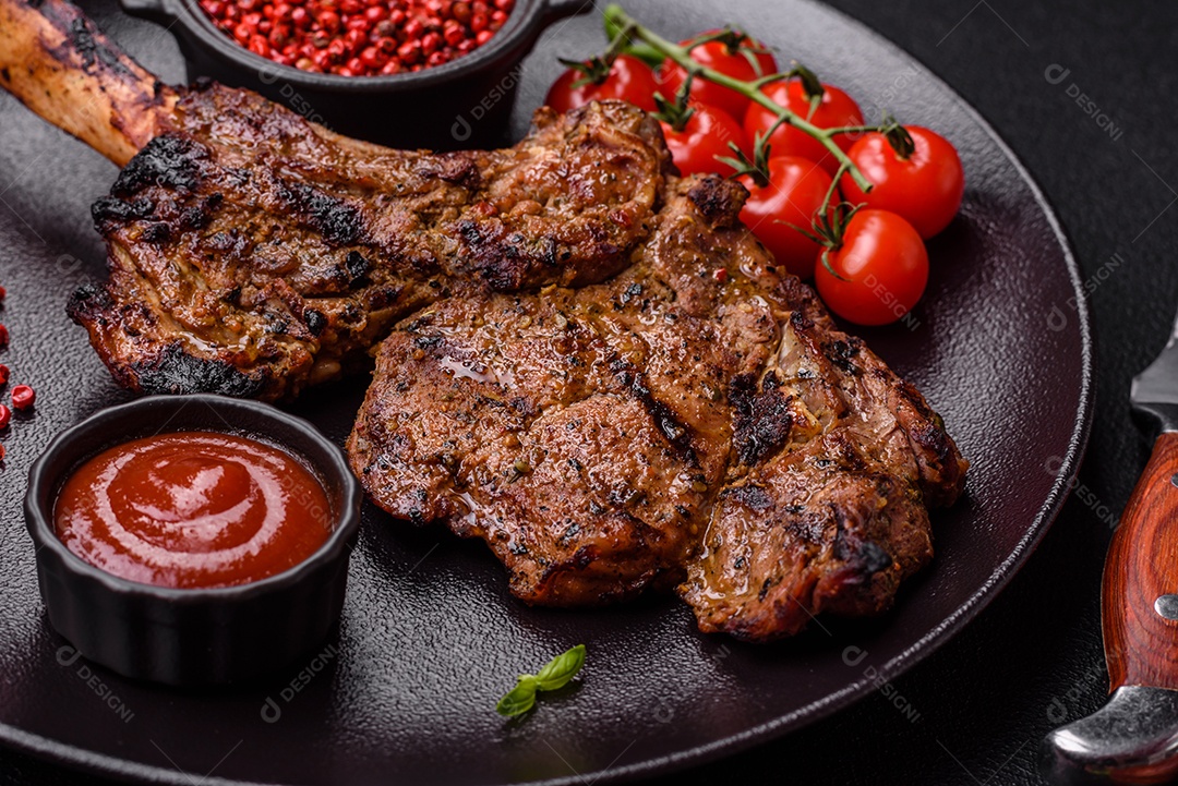 Bife suculento de tomahawk com osso assado na grelha com sal e especiarias em um fundo escuro de concreto