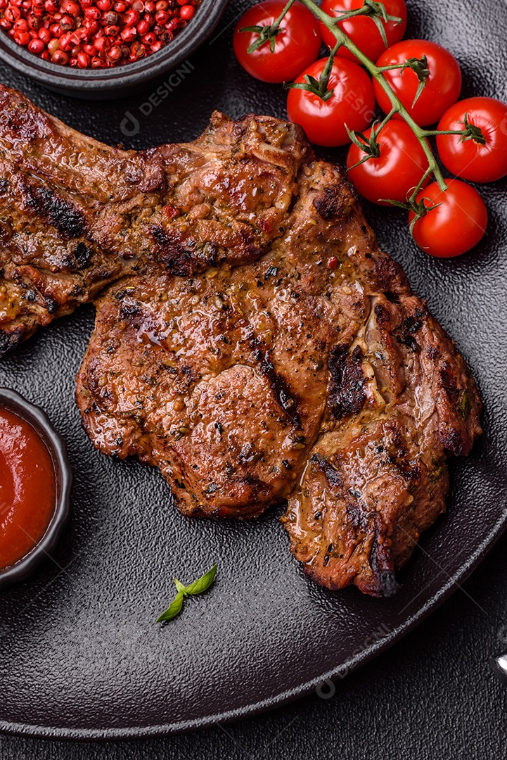 Bife suculento de tomahawk com osso assado na grelha com sal e especiarias em um fundo escuro de concreto