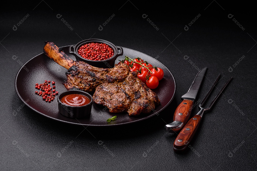 Bife suculento de tomahawk com osso assado na grelha com sal e especiarias em um fundo escuro de concreto