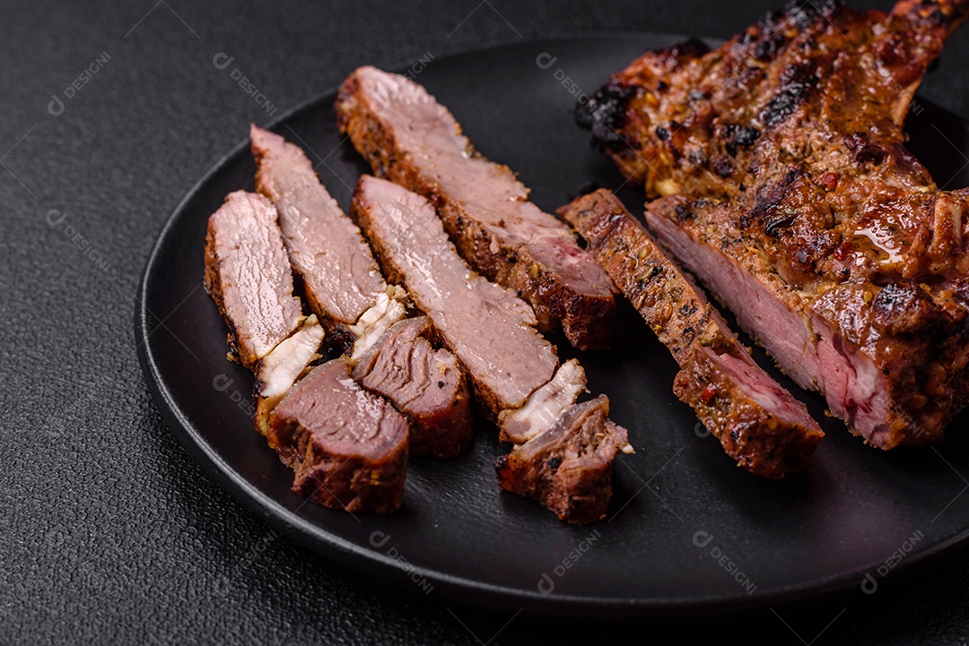 Bife suculento de tomahawk com osso assado na grelha com sal e especiarias em um fundo escuro de concreto