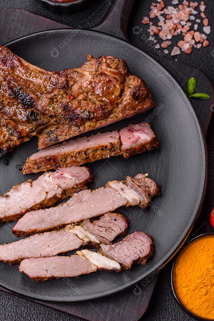 Bife suculento de tomahawk com osso assado na grelha com sal e especiarias em um fundo escuro de concreto