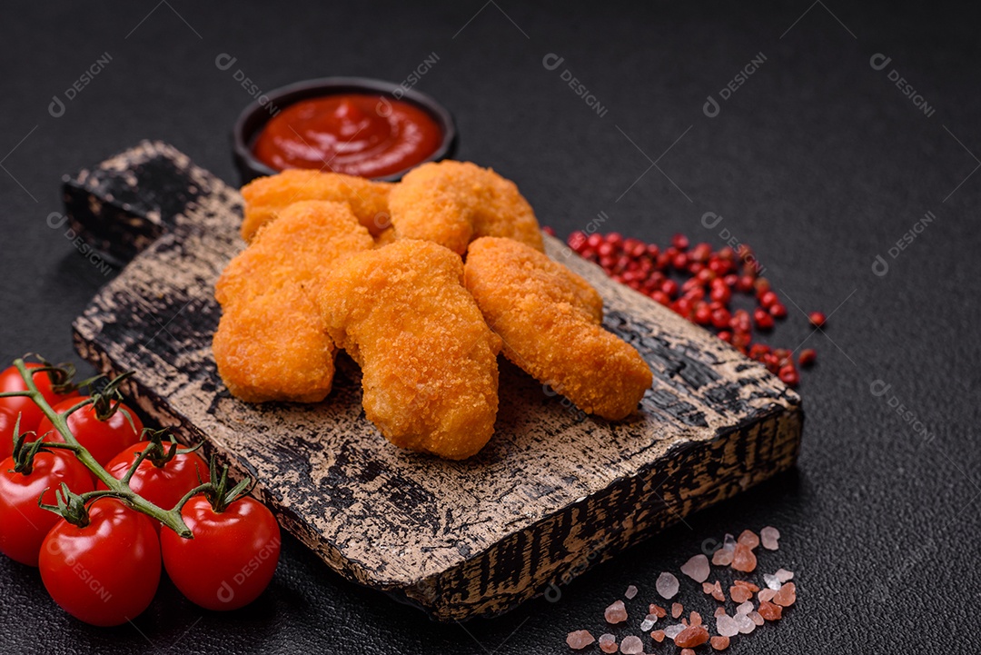 Deliciosos nuggets de frango crocantes frescos em um fundo escuro de concreto. Alimentos não saudáveis, fast food