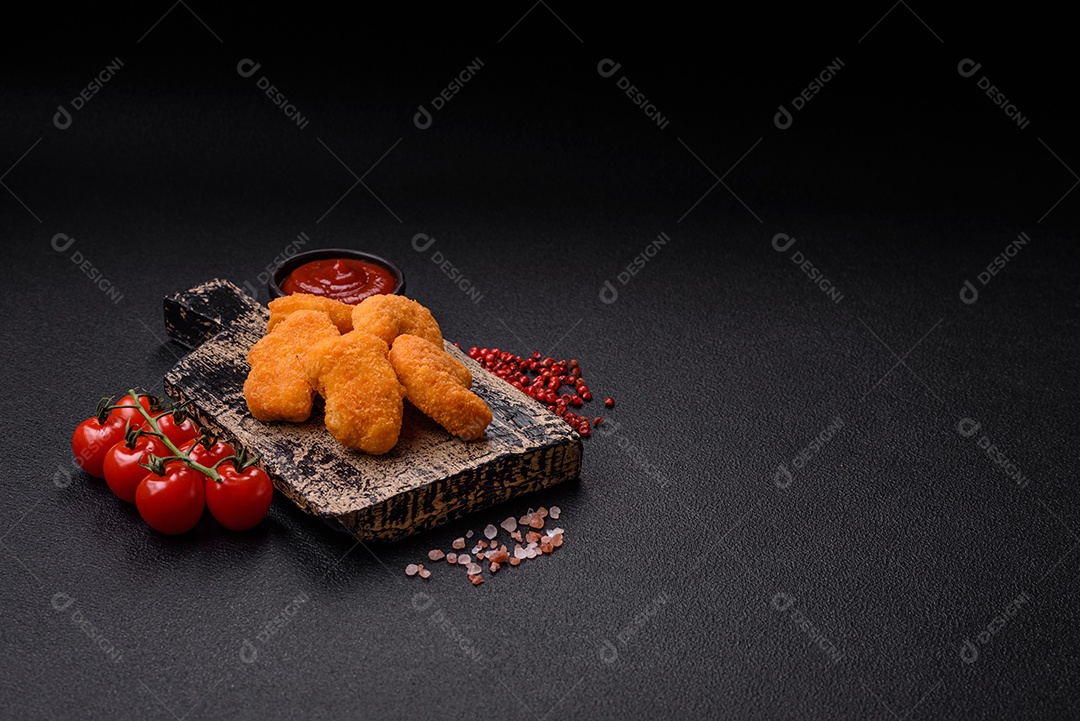 Deliciosos nuggets de frango crocantes frescos em um fundo escuro de concreto. Alimentos não saudáveis, fast food