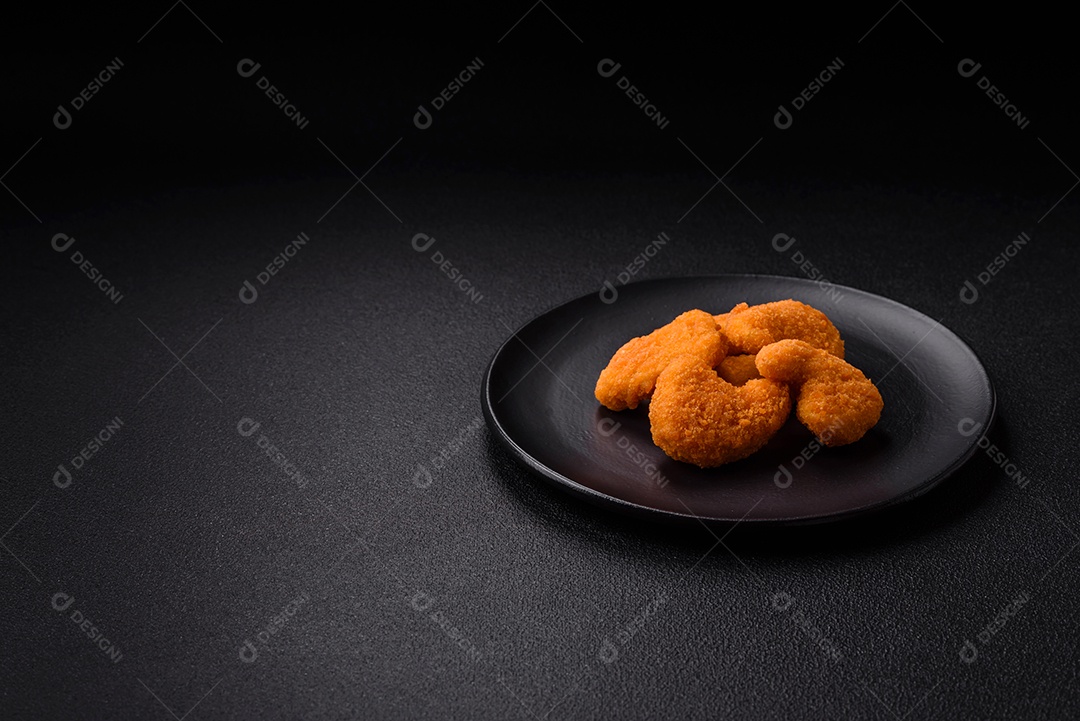 Deliciosos nuggets de frango crocantes frescos em um fundo escuro de concreto. Alimentos não saudáveis, fast food