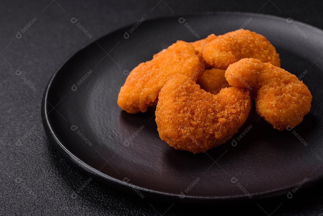 Deliciosos nuggets de frango crocantes frescos em um fundo escuro de concreto. Alimentos não saudáveis, fast food