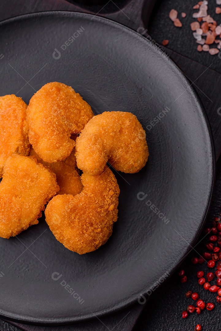 Deliciosos nuggets de frango crocantes frescos em um fundo escuro de concreto. Alimentos não saudáveis, fast food