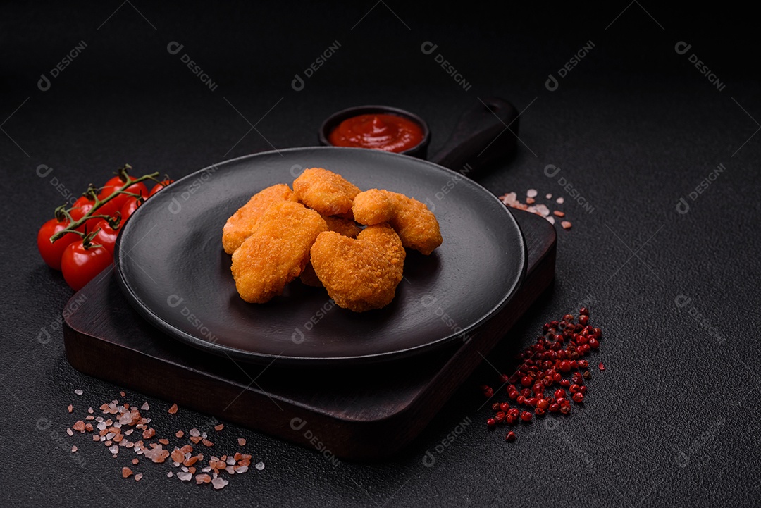 Deliciosos nuggets de frango crocantes frescos em um fundo escuro de concreto. Alimentos não saudáveis, fast food